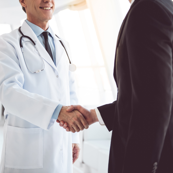 Two healthcare professionals shaking hands.