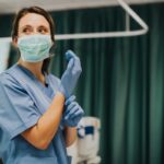 Healthcare worker in a hospital setting putting on PPE