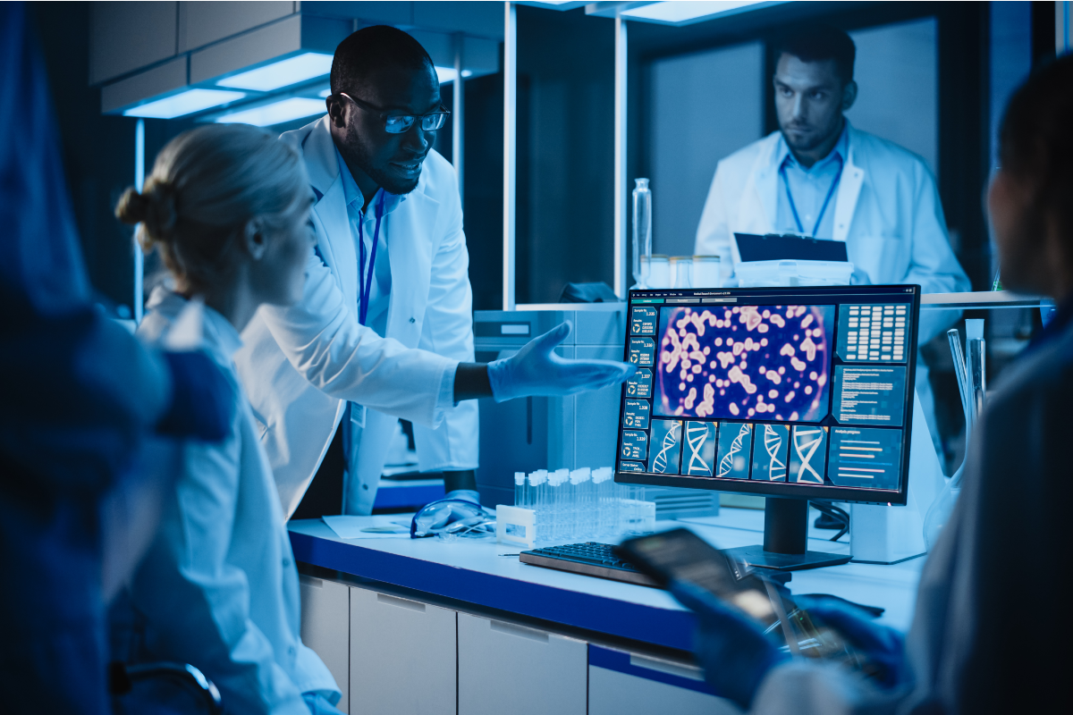 Multiple Health researchers looking and clinical research on a computer screen