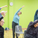 Elderly people exercising in a group.