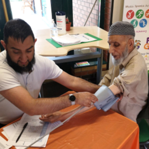 Mo carries out a blood pressure check at a community engagement event