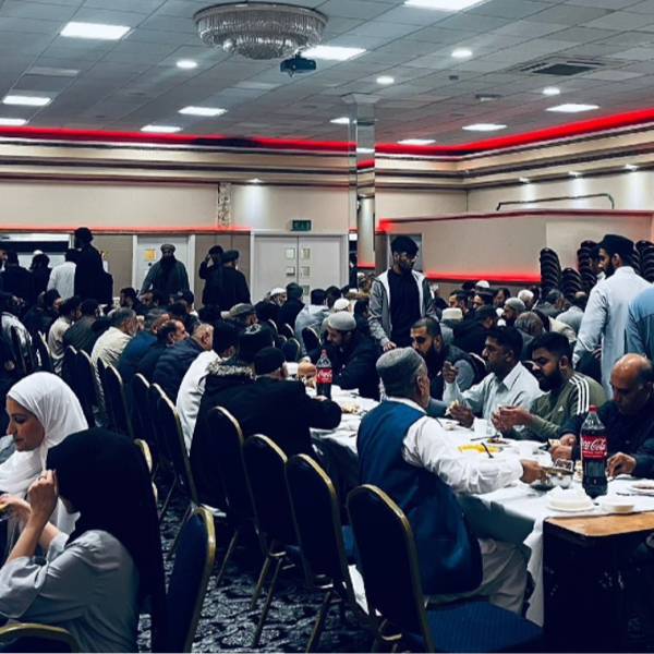 members of the community seated around table eating food